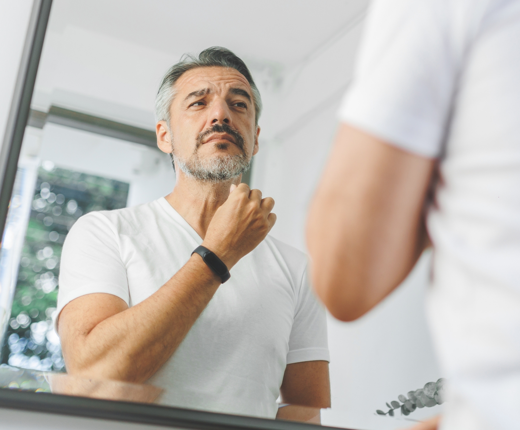 Man standing in mirror shaving