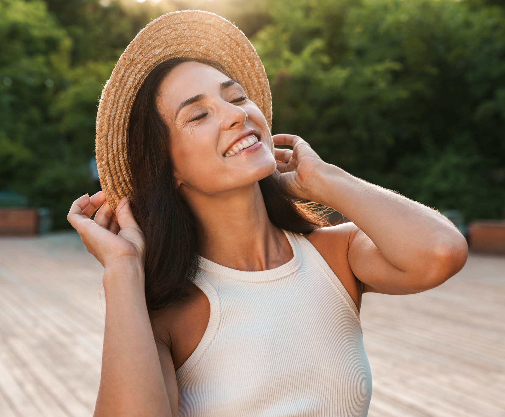 Woman wearing a hat and smiling in the sun