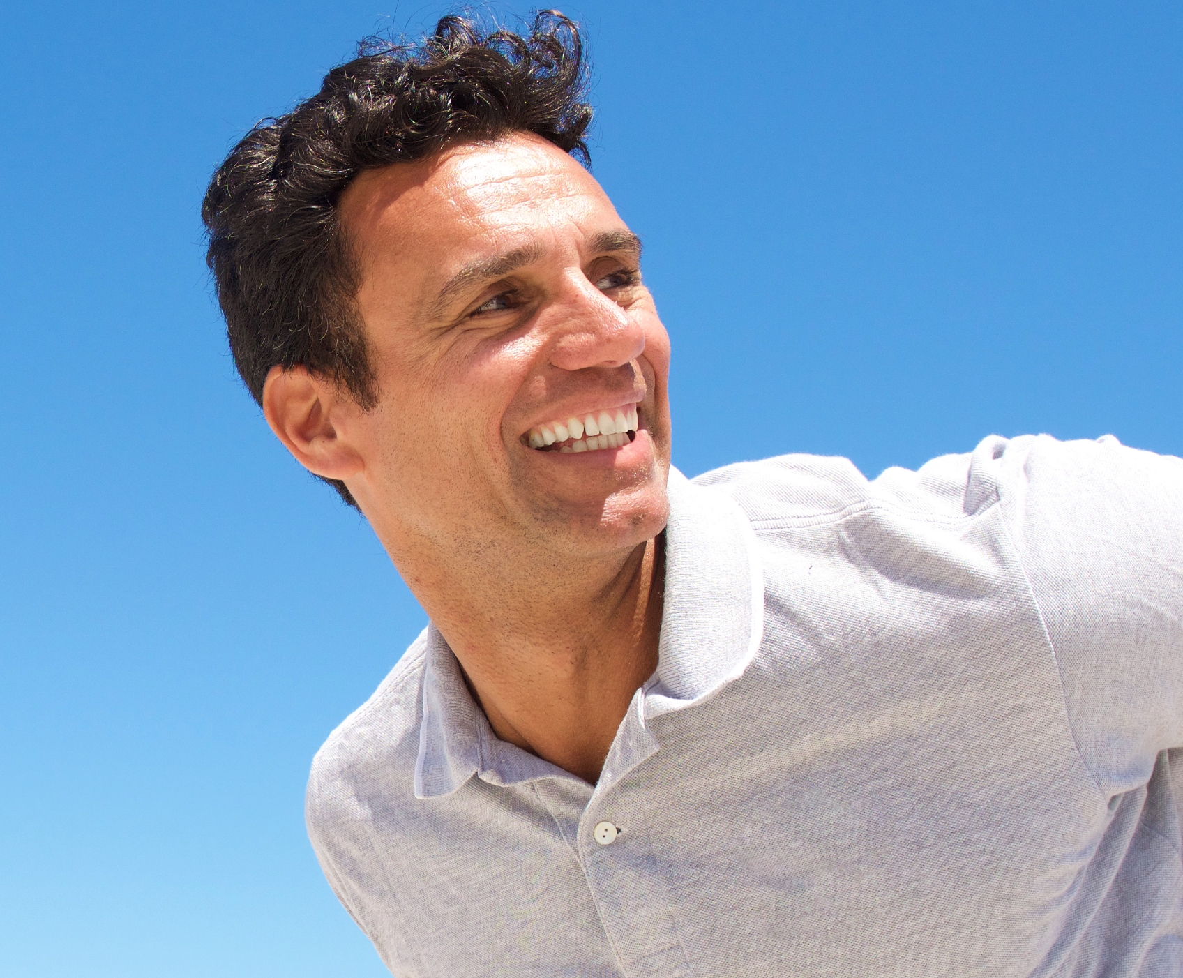Man standing and smiling wearing polo shirt