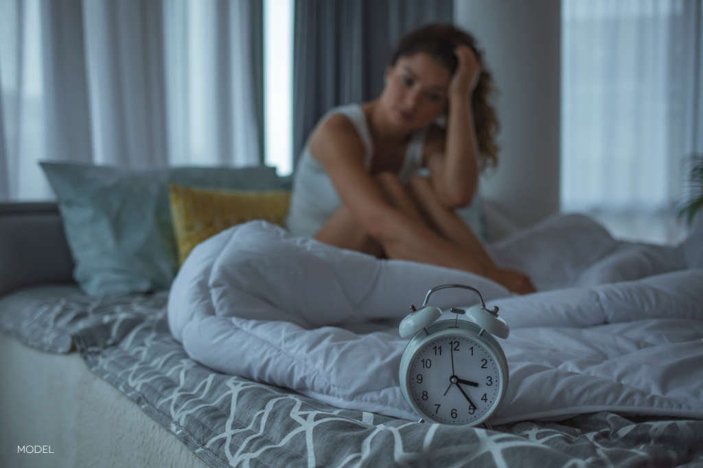 woman awake in the night, clock showing the time of 3:20