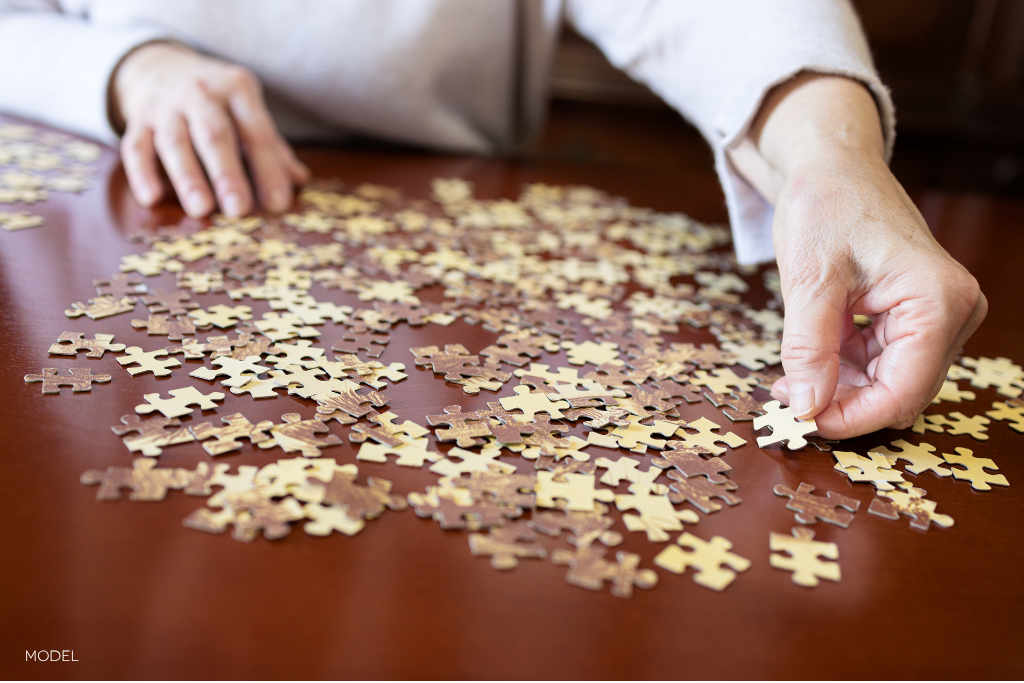 close up of hands doing a puzzle